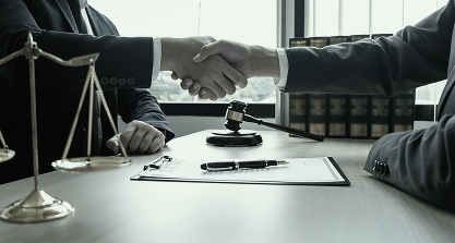 Attorney and client shaking hands over a legal agreement